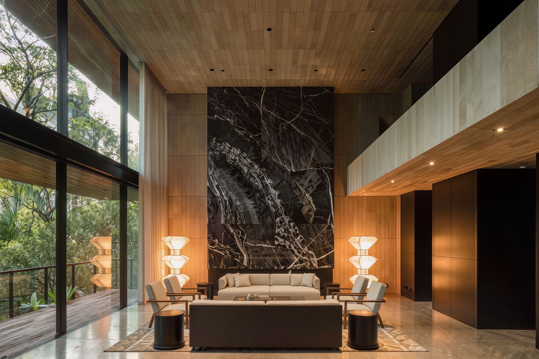 Sala de doble altura con muro de ónix