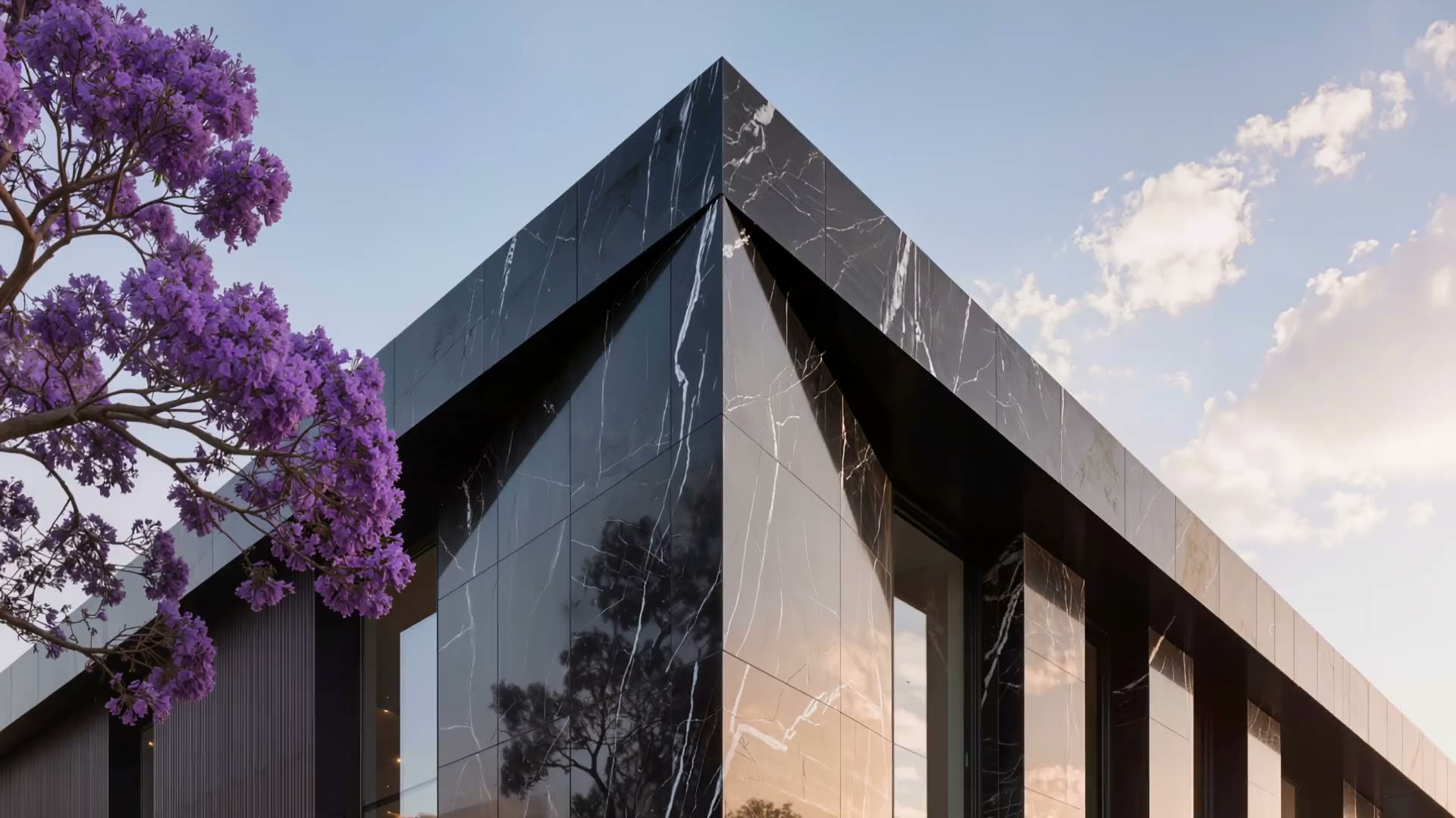 Esquina de un edificio residencial de piedra negra en Polanco con jacarandas